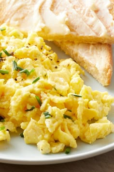 scrambled eggs and toast on a white plate