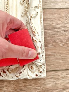 a person with their hand on a piece of red paper