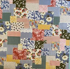 an old patchwork quilt with many different colors and patterns on the fabric, including flowers