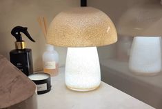 a mushroom shaped lamp sitting on top of a counter next to a bottle and soap dispenser