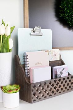 a desk with flowers and notepads in a holder next to a framed photo