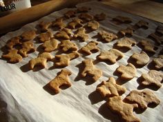 a bunch of cookies that are sitting on a sheet of paper next to a cup