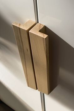 a pair of wooden sticks sticking out of the side of a white wall next to a window