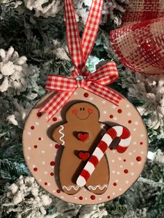 a christmas ornament with a gingerbread man holding a candy cane on it