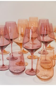 many different colored wine glasses lined up together