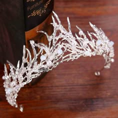 a tiara made out of crystal beads on top of a wooden table next to a book