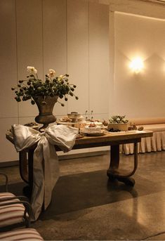 a table with flowers and food on it in front of a wall that has lights