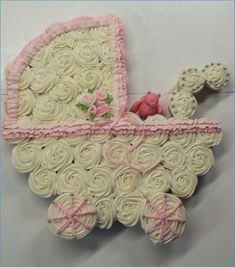 a cake shaped like a baby's carriage with pink trimmings and flowers