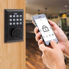 a person holding a smart phone in front of an electronic door lock