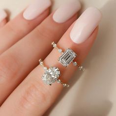 a woman's hand with two rings on it and one is wearing a diamond ring