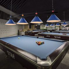 a pool table with several lights hanging above it