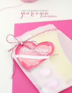 a valentine's day card with a heart shaped tag attached to the front of it