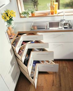 an organized kitchen with drawers in the middle