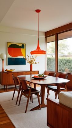 a dining room table with chairs and a painting on the wall