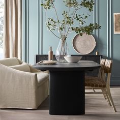 a dining room with blue walls and wooden flooring is pictured in this image, there are two chairs around the table