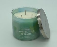 a white tea and sage candle in a glass container