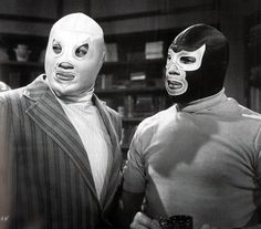 two men wearing masks standing next to each other