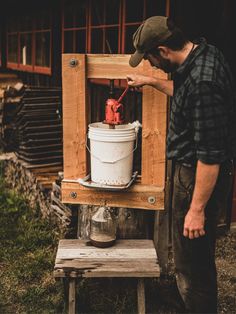 a man is working on an old fashioned ice cream bucket with a red fire extinguisher in it