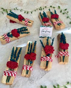 small wooden sticks with flowers and ribbons tied around them on a white tablecloth covered surface