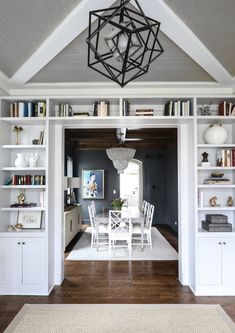 a dining room table and chairs in front of bookshelves with shelves on each side