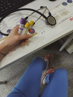 a person sitting at a desk with a computer keyboard and various medical equipment on it