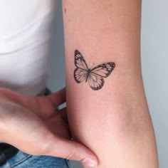 a small butterfly tattoo on the left inner arm and wrist is shown in black ink