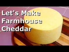 a cheesecake sitting on top of a wooden cutting board with the words let's make farmhouse cheddar