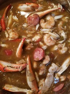 there is a stew with shrimp and sausage in the pot, ready to be eaten