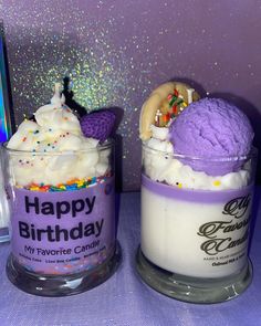 two cups filled with ice cream and toppings on top of a purple table cloth