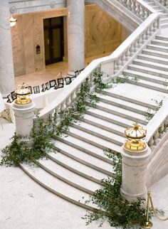 the stairs are decorated with greenery and gold decorations on them, along with marble pillars