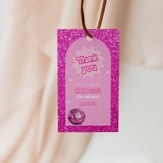 a pink thank you card hanging from a string