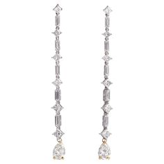 These stylish 18K gold long drop earrings are designed with an elegant linear drop that alternates between baguette and square-cut diamonds, culminating in a beautiful pear-cut diamond drop. The diamonds are natural with exceptional brilliance, totaling Esstimated approx. 6.00 carats. 24 diamonds are of VS clarity and G-H( one pear diamond is a natural yellow color, offering a radiant sparkle perfect for bridal occasions, evening parties, or the holiday season. Measurement: 2.5 inches in length Weight: 6.6 grams These dangle drop earrings are secured with push-back closures, ensuring both comfort and security. Their refined and elongated design makes them an ideal accessory for any occasion. Accompanied by Gemologist Appraisal Document. Luxury Rectangular Anniversary Earrings, Luxury Elegant Rectangular Diamond Earrings, Luxury Long Drop Linear Earrings - Fine Jewelry, Luxury Brilliant Cut Drop Linear Earrings, Luxury Long Drop Single Earring, Luxury Diamond Linear Long Drop Earrings, Dulong Fine Jewelry, Long Diamond Earrings, Large Dangle Earrings