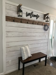 a bench sitting in front of a wooden wall with hooks on it's sides