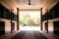 an open door leading into a building with black shutters on both sides and a ceiling fan hanging from the ceiling