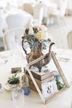 a table topped with a vase filled with flowers next to a clock and other items