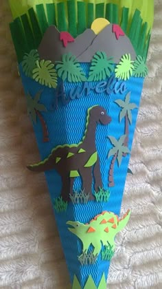 a paper cone with dinosaurs and palm trees on it