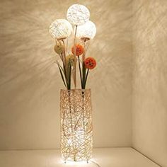 a vase filled with flowers sitting on top of a white shelf next to a wall