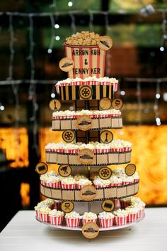 a three tiered cake with popcorn buckets on top