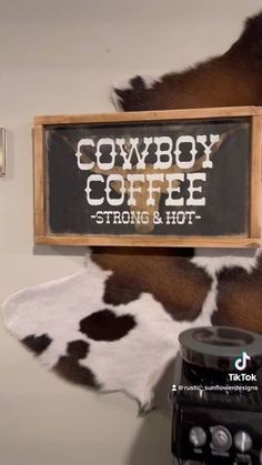 cowboy coffee sign hanging on the wall next to an old fashioned radio and cowhide rug