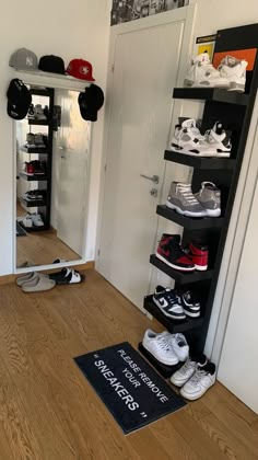 there are many pairs of shoes on the floor in front of a mirror and door