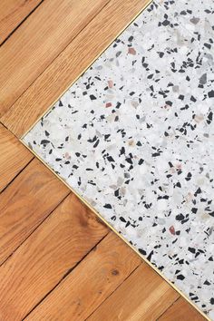 the floor is covered in white and black speckles, with wood floors below