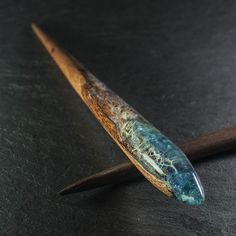 a wooden object with blue and green paint on it's end sitting on a table