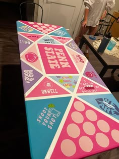 a man standing next to a table covered in pink, blue and white stickers