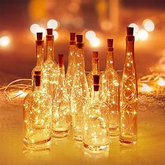 several bottles with lights in them sitting on a table