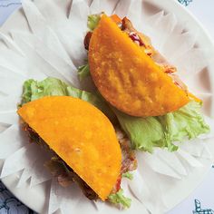 two tacos sitting on top of a paper plate