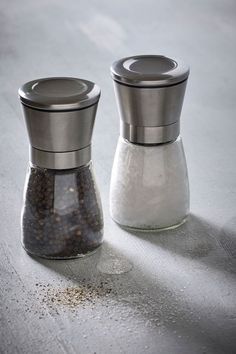 two salt and pepper mills sitting on top of a table