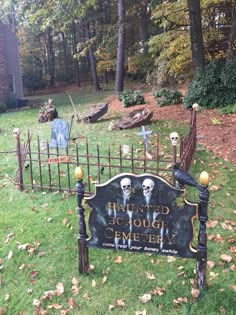 a sign that is in the grass with some decorations on it and there are trees