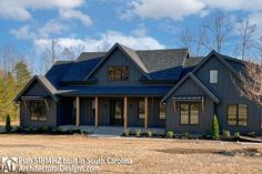 a large blue house sitting in the middle of a field