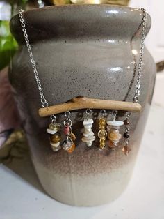 a vase with a wooden stick and several charms hanging from it