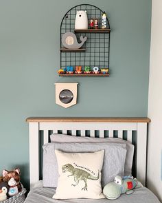 there is a bed with a pillow and stuffed animals on the headboard next to it